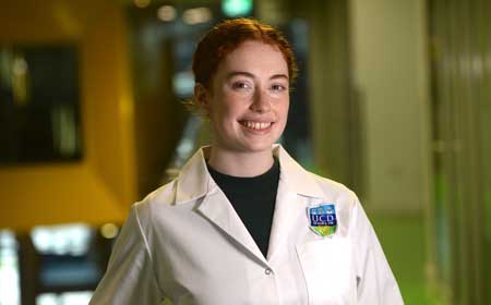A smiling girl in a lab coat