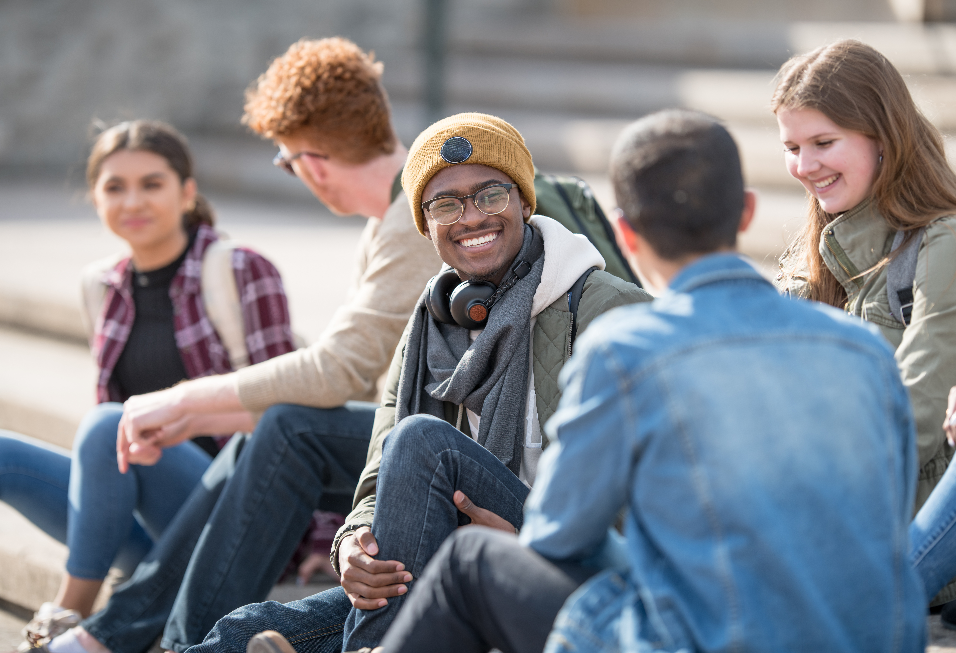 Group of students sitting outside and having a friendly discussion