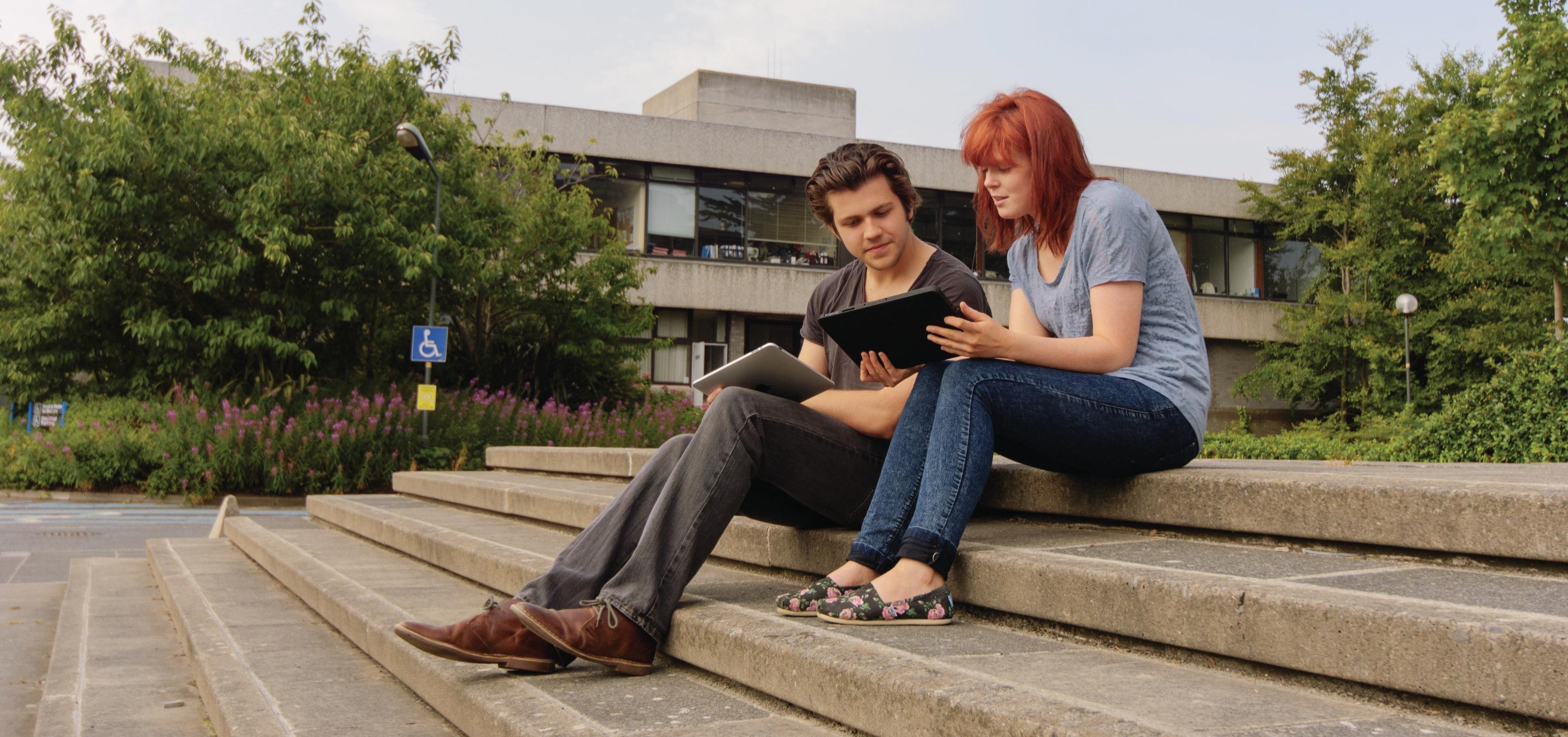 Students sitting outdoors on UCD Belfield campus