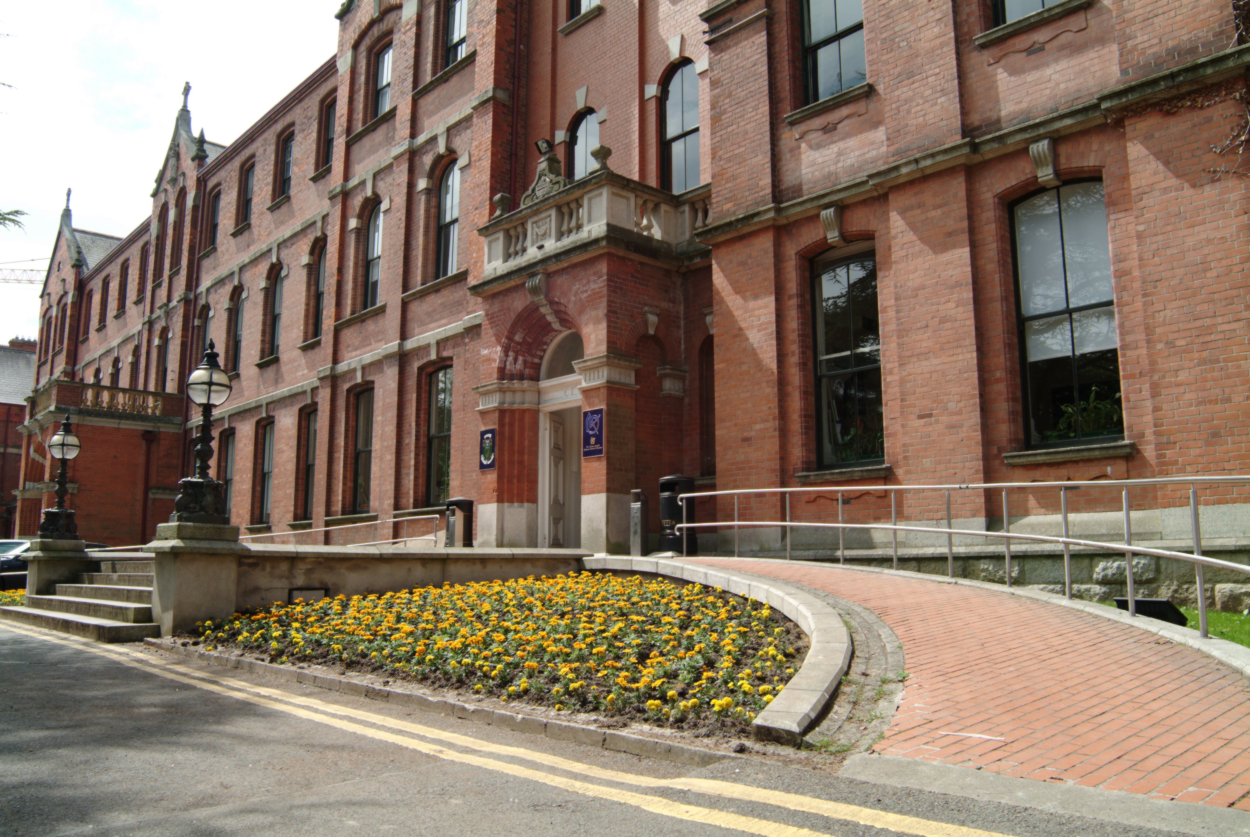 A redbrick building with flowers at the front