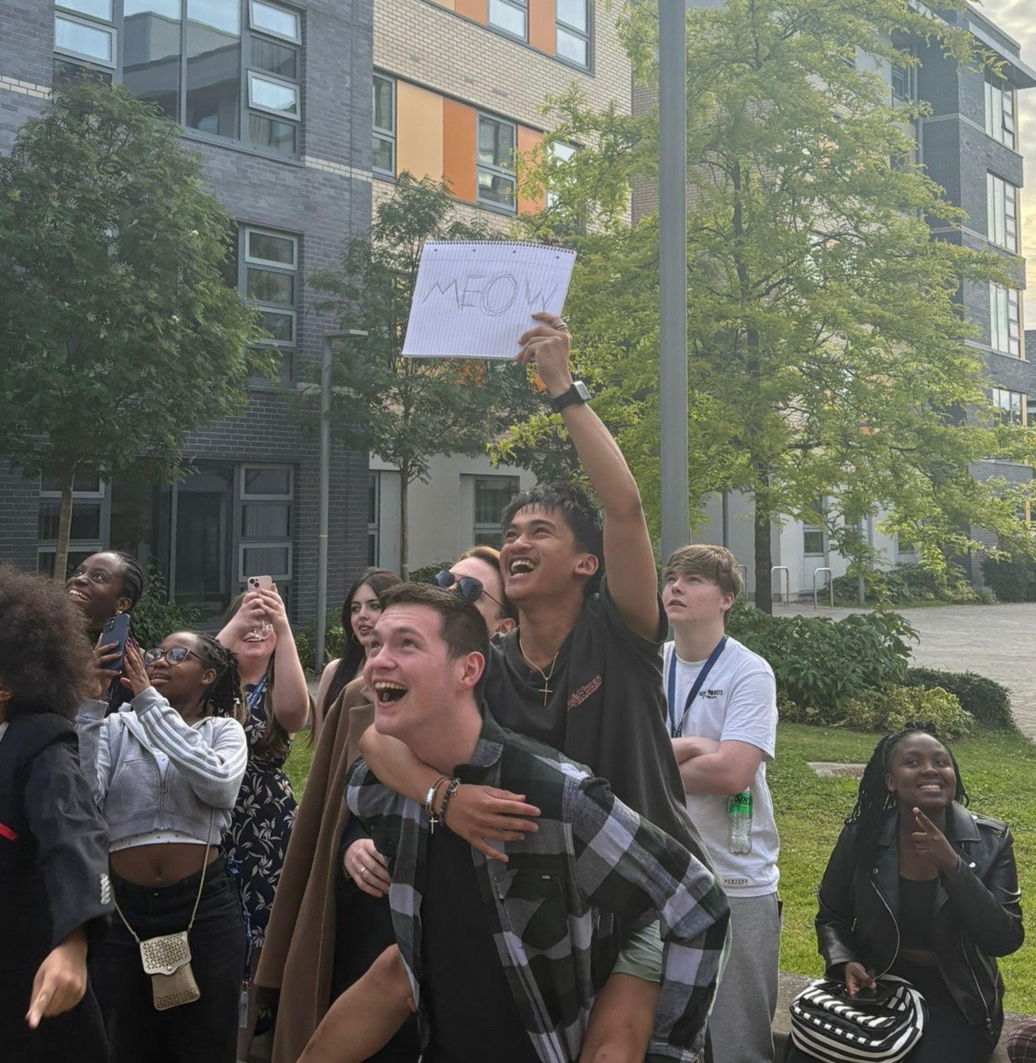A group of students having fun in front of the Ashfield residences during the summer school 2025