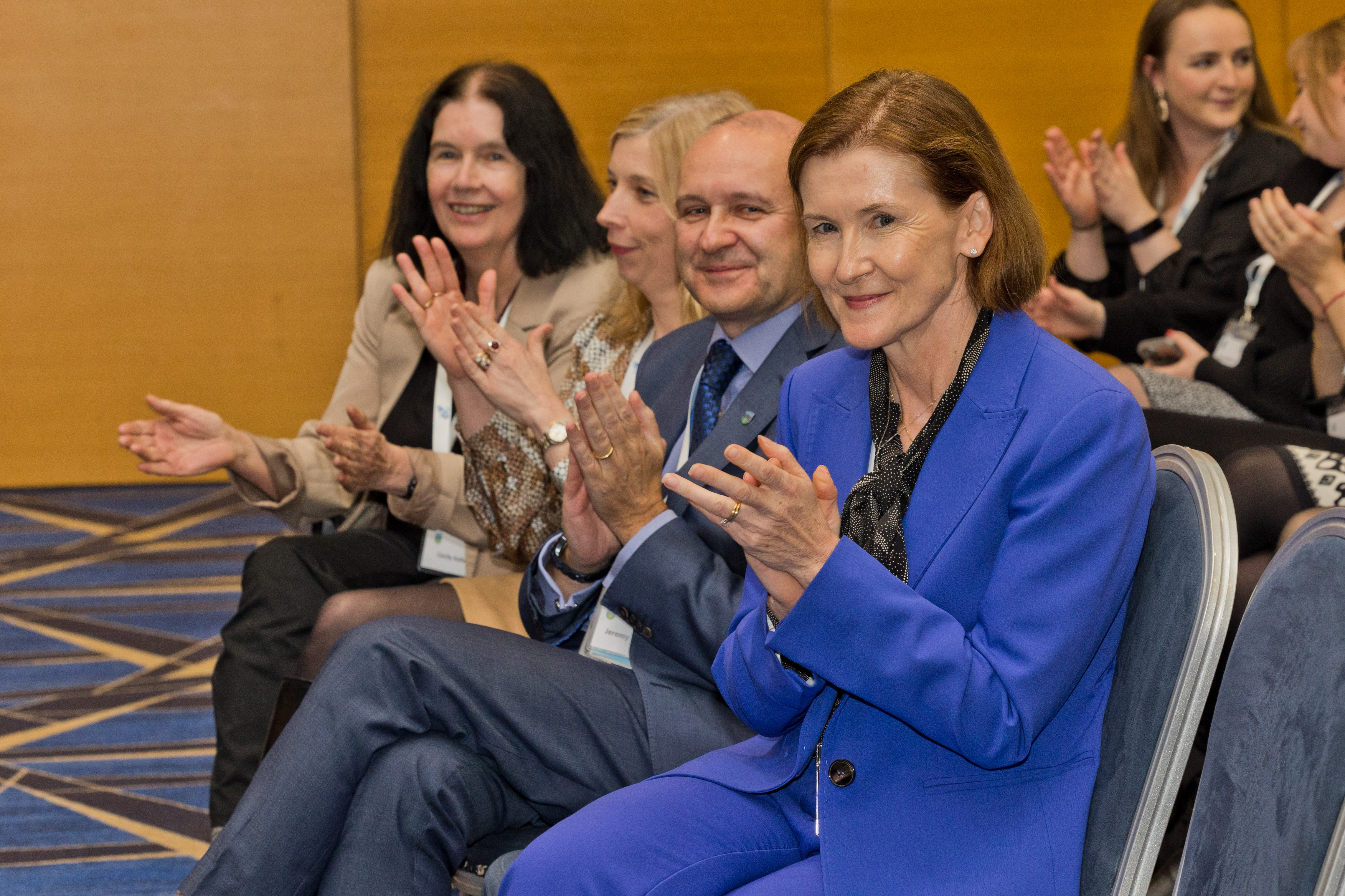 Four people in O'Reilly Hall clapping