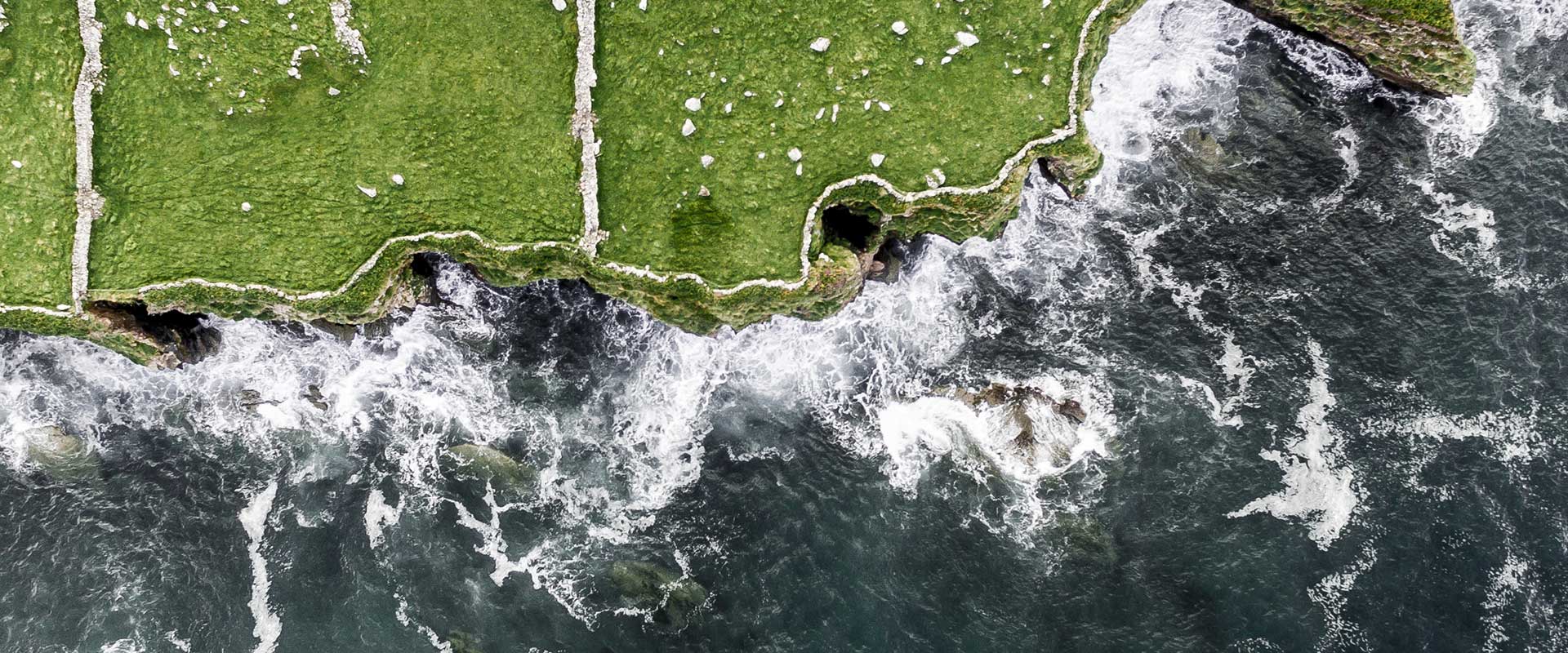 Illustrative overhead shot of an Irish coastline with rough seas and waves