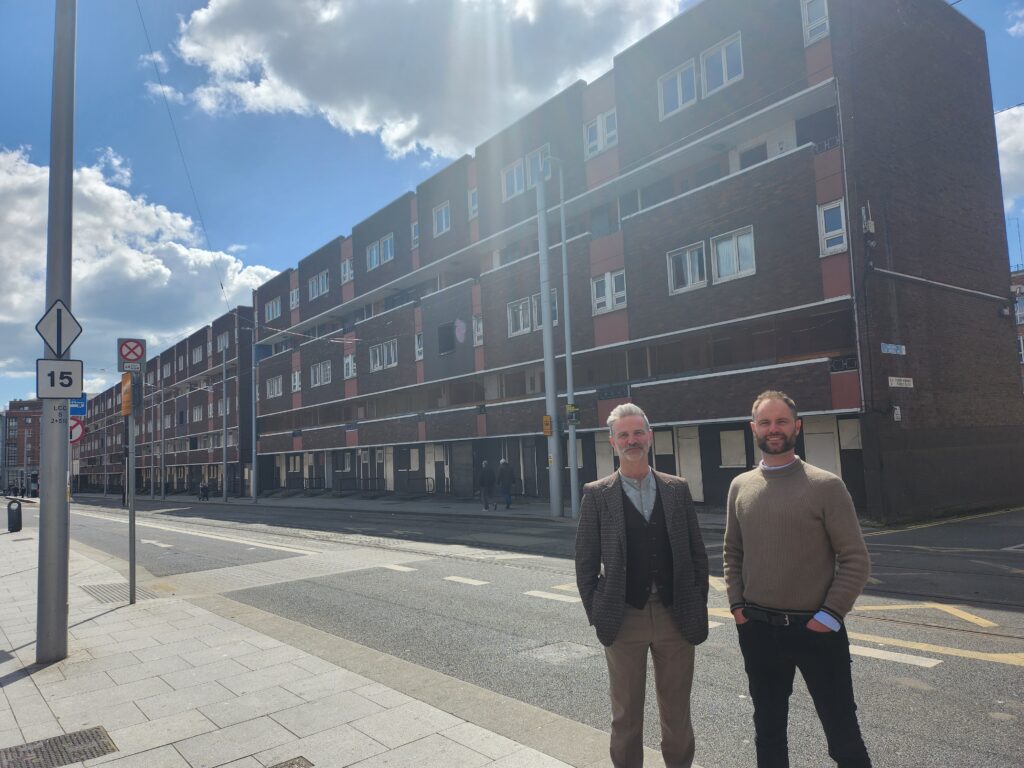 two people in front of a red building