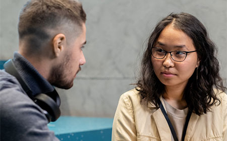 Two UCD students sit and chat together.