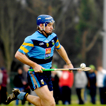 A hurling player balances a sliotar on a hurl.
