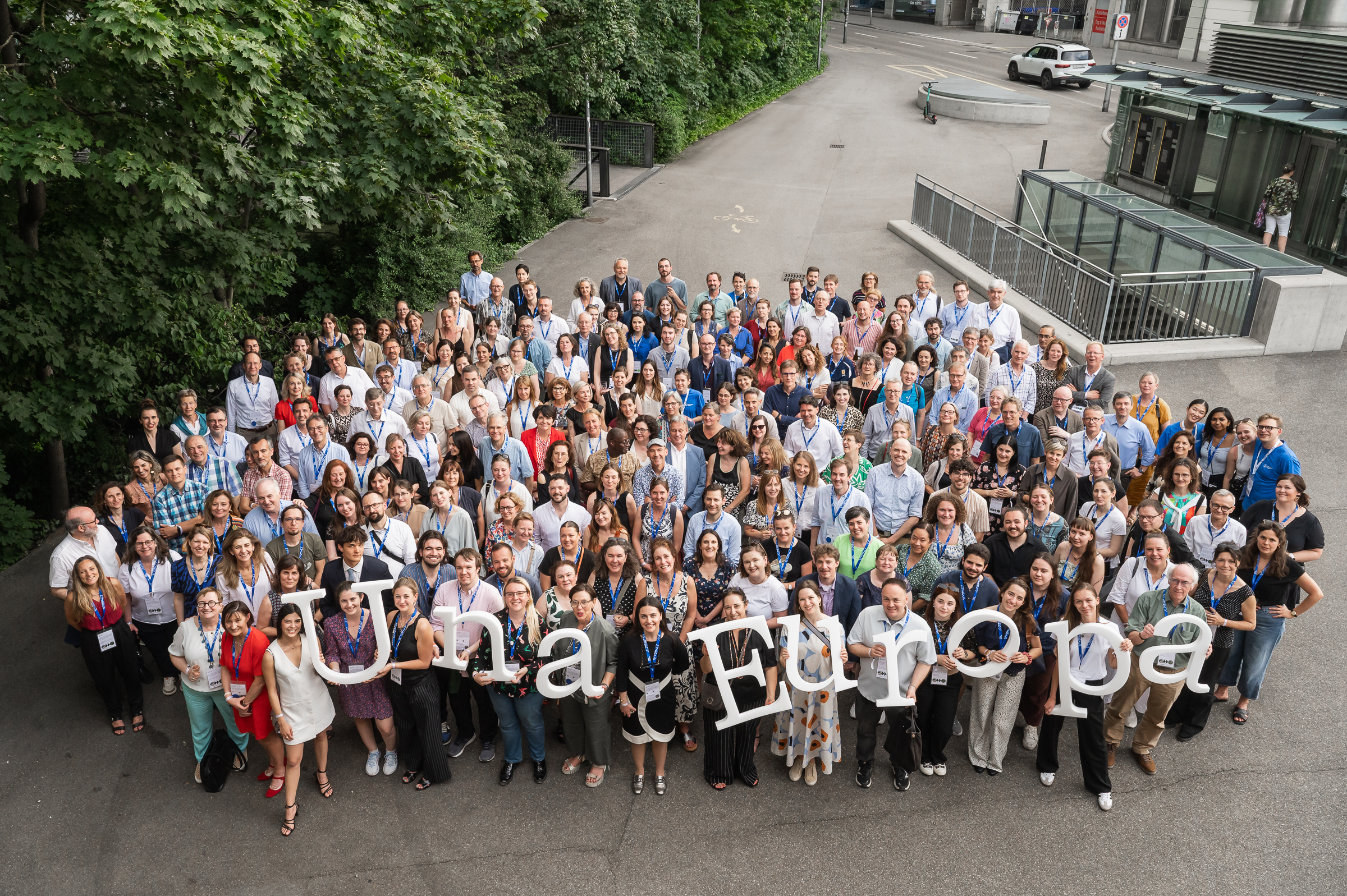 A large group of people outside holding an Una Europa sign.