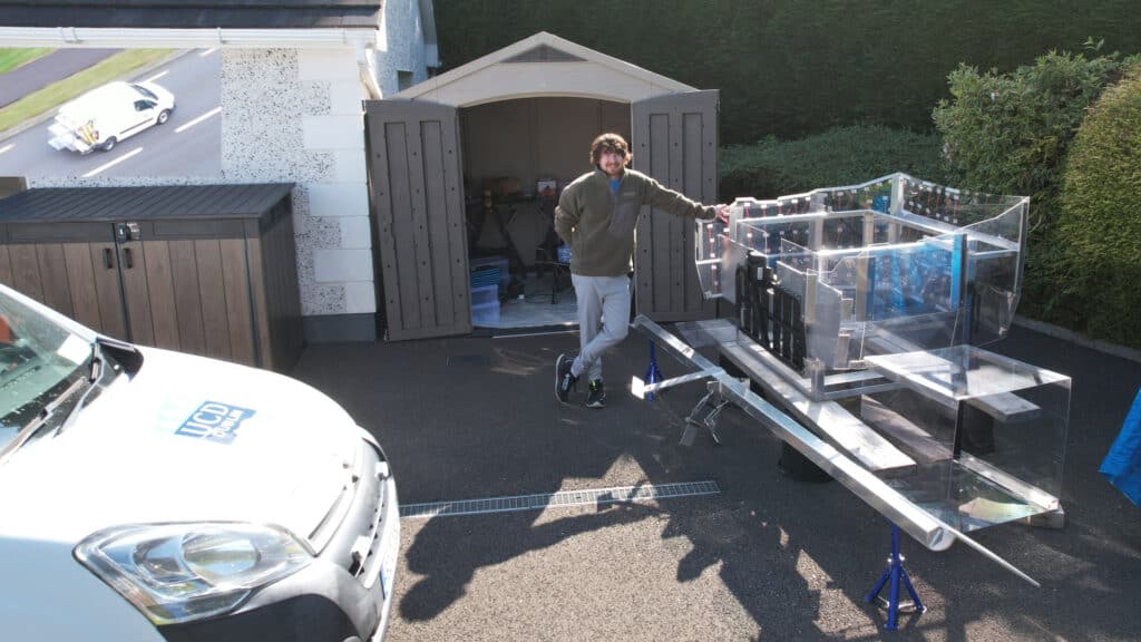 A photo of UCD PhD student Michael Connelly with the fuel-saving drag-reduction device for road vehicles, he has developed.