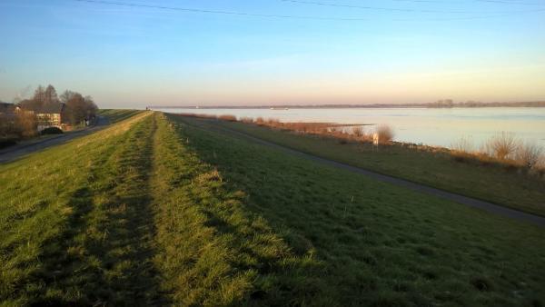 Tidal Elbe Germany showing a grass-covered dyke next to the river