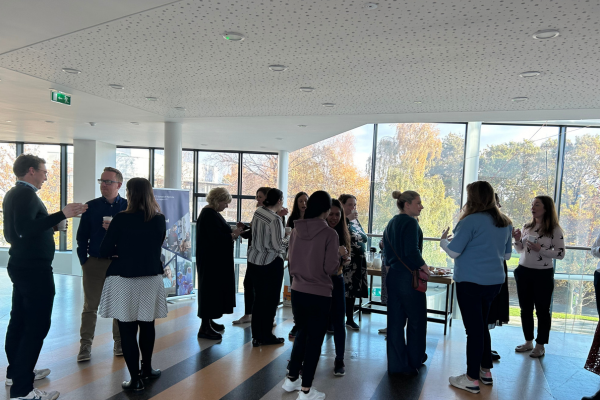 Staff standing around talking at coffee morning