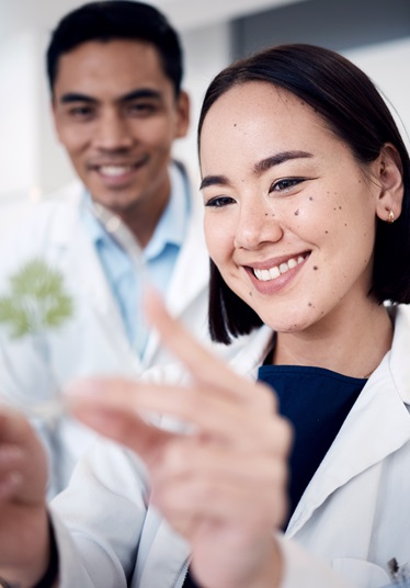 two people in lab coats looking at a petri dish decorative