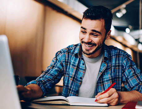 Man smiling on laptop.