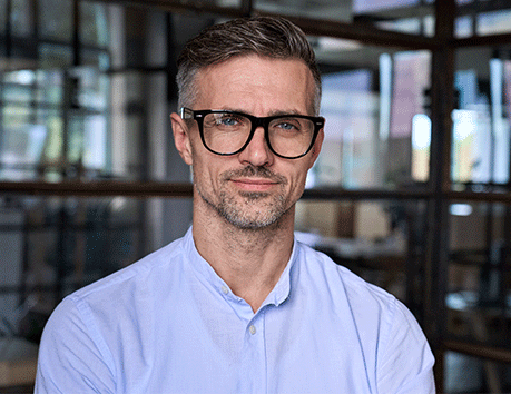 man with glasses smiling at camera