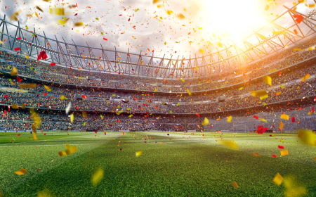 Large crowded sports stadium with confetti flying in foreground