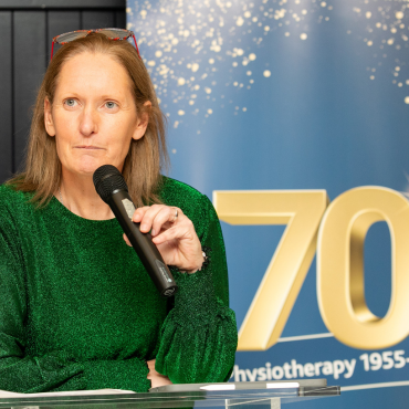 Woman in green top speaking at the UCD Physiotherapy 70th anniversary celebration