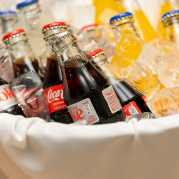 Close up of bottles of coke and other drinks bottles in an ice bucket