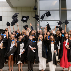 UCD graduates throwing caps in air