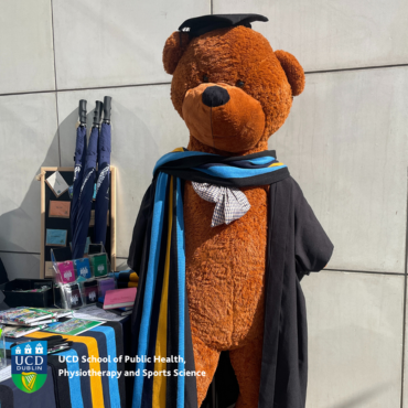 Large teddy bear dressed up at UCD graduate in cap and gown and UCD scarf