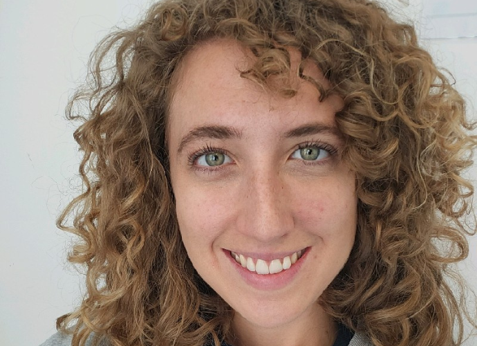 Image of a female with dark curly hair smiling