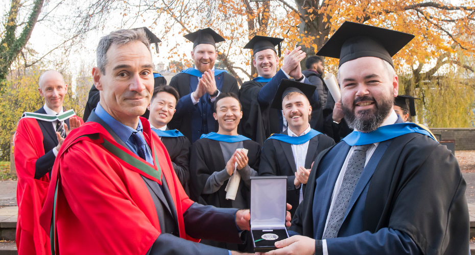 Graduating student receiving a medal from an academic