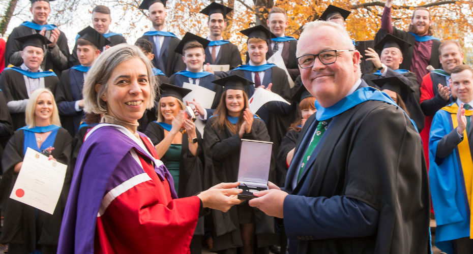 Graduating student receiving a medal from an academic