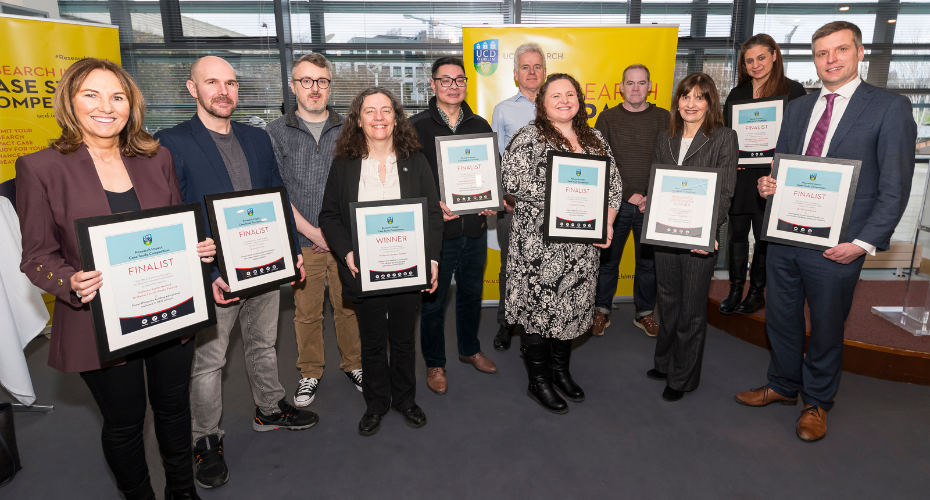 Group of people holding awards in front of a yellow backdrop