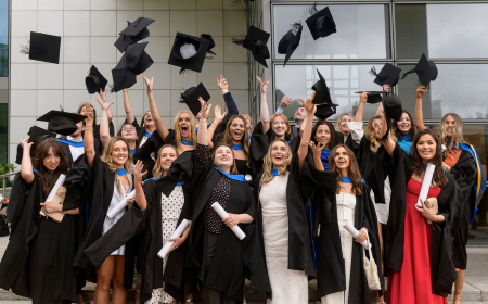 Class of graduates throwing their caps in the air