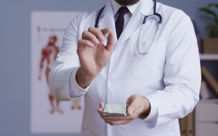 Healthcare professional in white coat using digital device