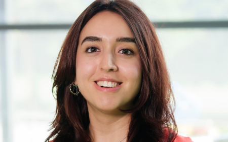 Woman with long dark hair smiling to camera