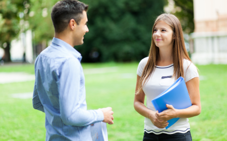 Two students talking on a lawn