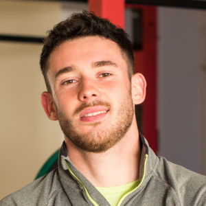 Man with dark hair looking to camera