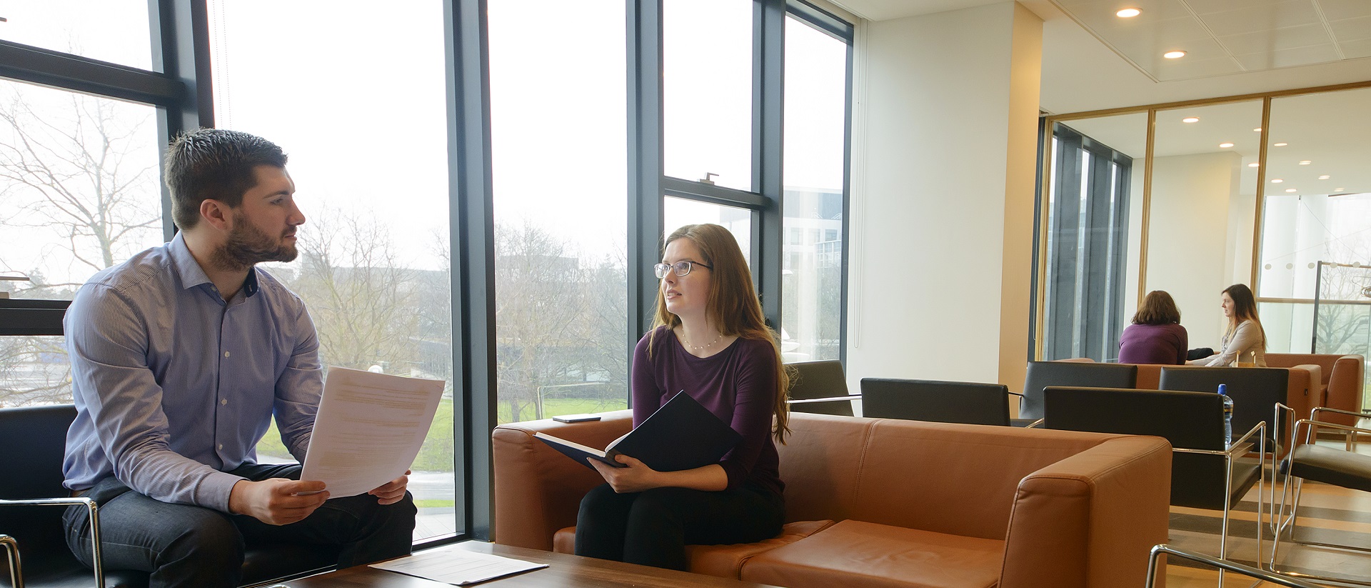 Two people sitting on a sofa chatting-decorative