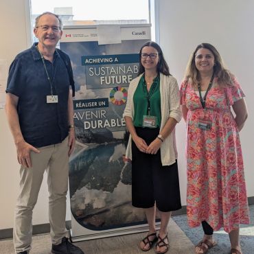 three people in front of a banner