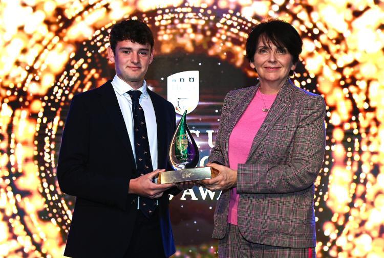 team captain Jack Fahy on stage to receive the trophy from the President.