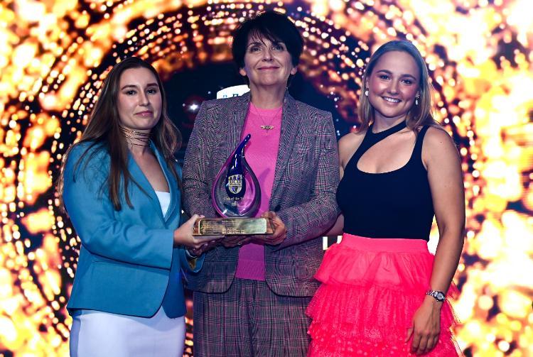 Shauna Fitzsimons of the Men’s Boat Club and Ellie Scott of the Ladies Boat Club on stage to receive the award from Prof. Feely.