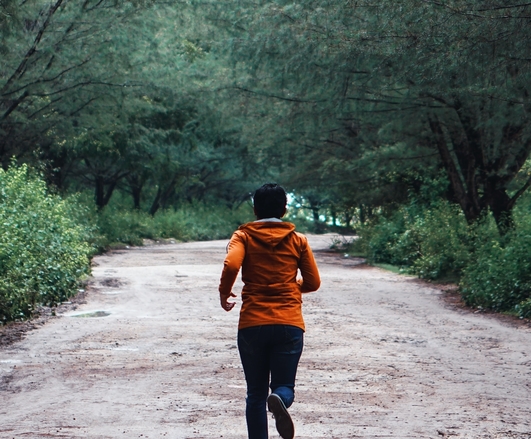 A runner on a trail through the forest