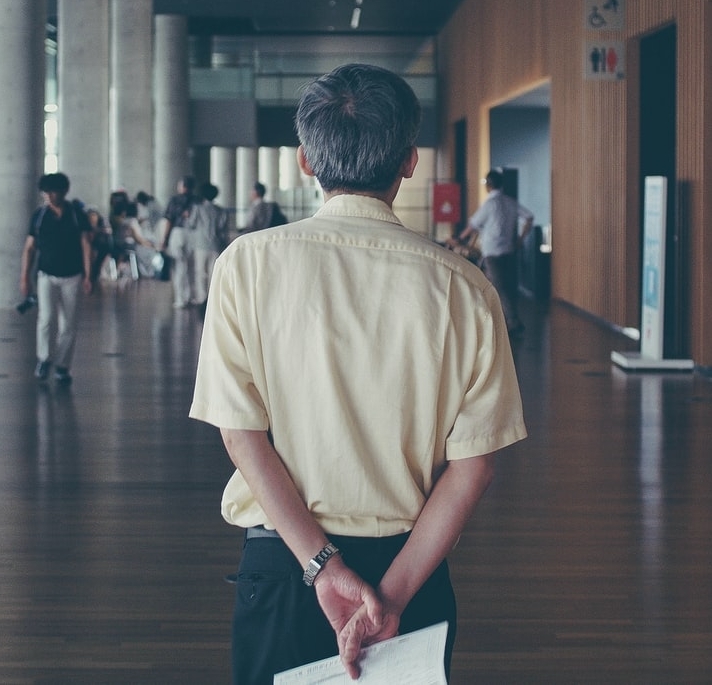 A staff member looking forward on a corridor of students