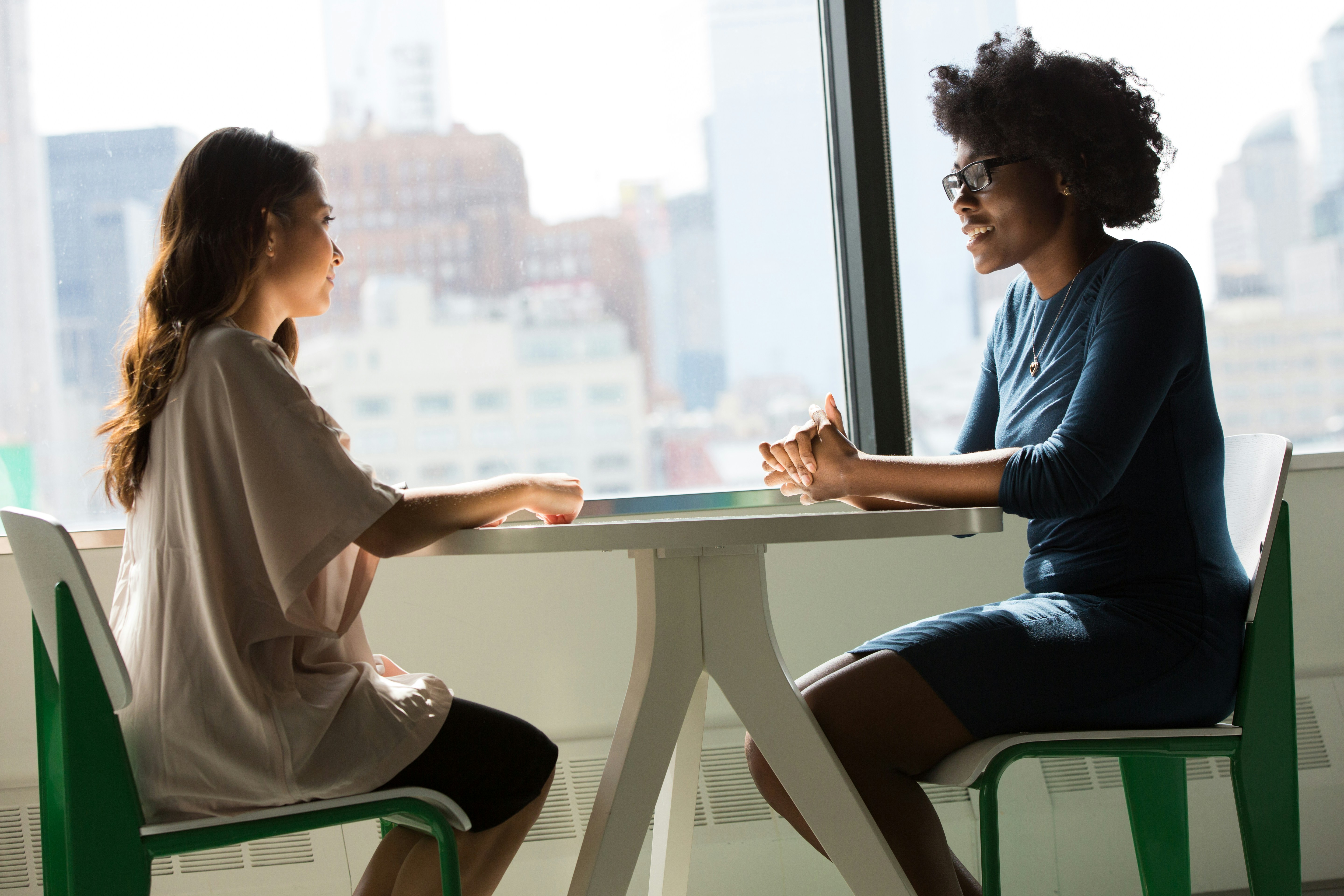 Two women sitting at a table, having a discussion