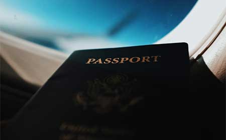 Passport in front of a plane window.
