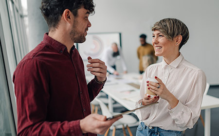 Man and woman chat and laugh over coffee.