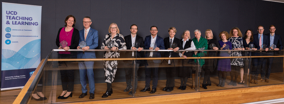 The winners of the 2021-22 UCD University Teaching and Learning Awards, standing in a line along a railing.