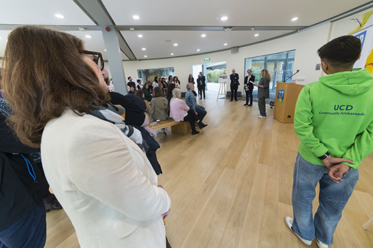 People listening to speakers at the launch of the community engagement report