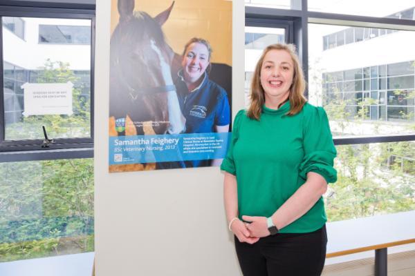 Samantha Feighery with her image on the Alumni Wall