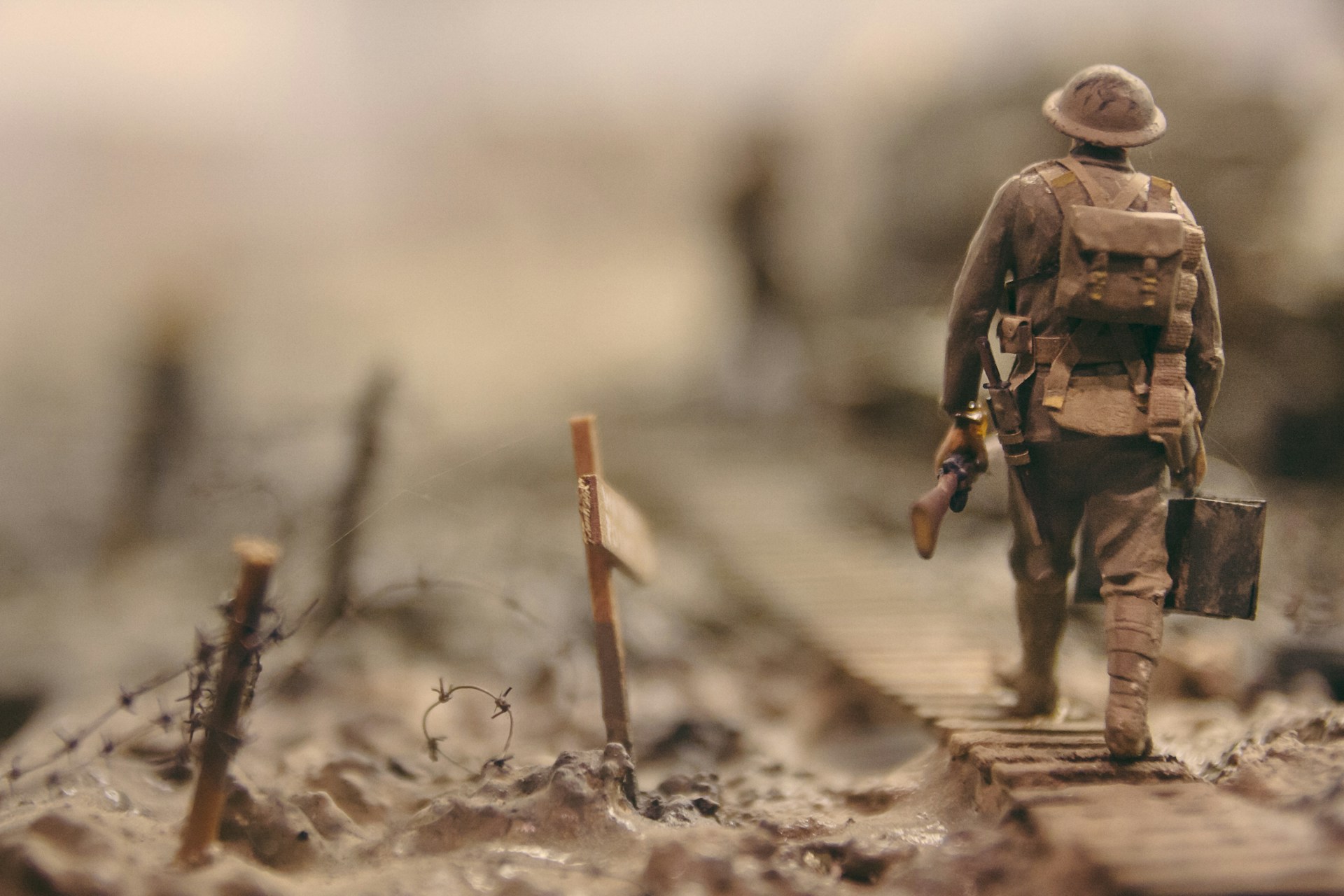 soldier-walking-on-wooden-pathway-surrounded-with-barbwire